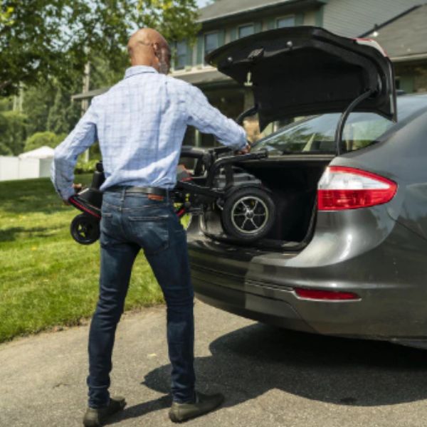 Man puttingthe folded up Feather Lightweight Electric Scooter in the back trunk of a car