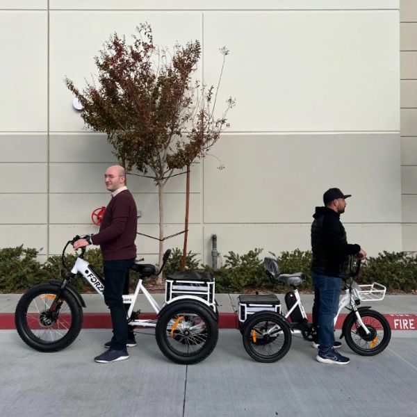 Two men standing on the GoBike Trio and Forza Electric Tricycle