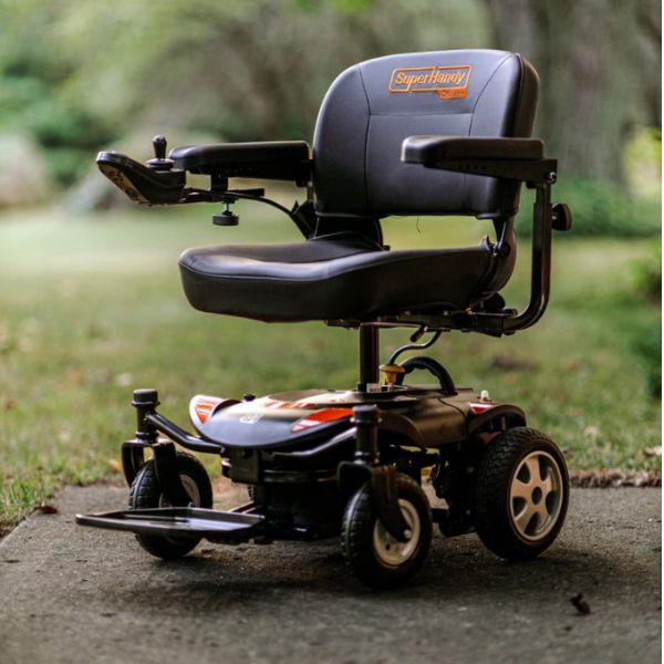 SuperHandy GoRide CRZ Portable Power Wheelchair with &#39;SuperHandy&#39; branding on a paved surface with grass in the background