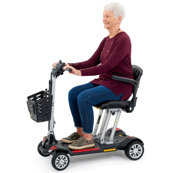 Golden Technologies Buzzaround Carry On Folding Mobility Scooter GB120 Orchid Red Color with Female Rider View