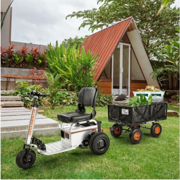 Mobility scooter with a trailer attached, parked in a garden setting.