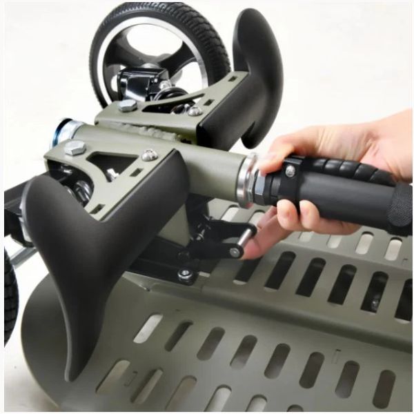 Hand holding a green SuperHandy Passport Pro Folding Mobility Scooter with black handlebar against a white background